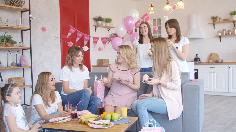 webbabyshower mom chatting with friends at baby shower party with little foods and drinks