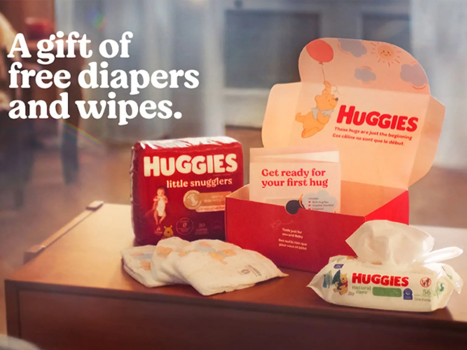 Baby diaper gift set with Huggies diapers and wipes on a wooden surface.