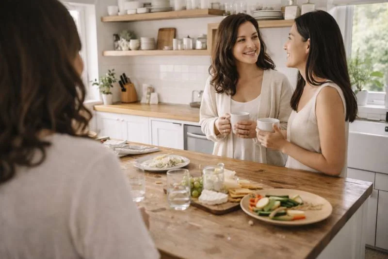 Happy women chatting at a modern kitchen for a baby shower.