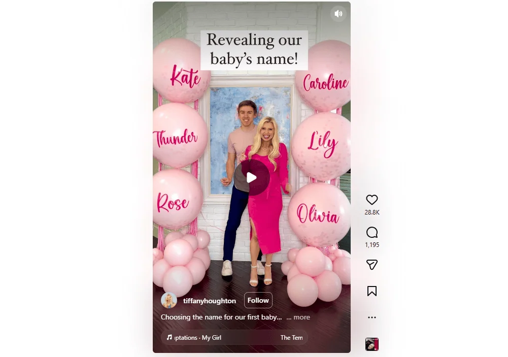 Couple revealing baby's name with pink balloons and decorations at gender reveal event.