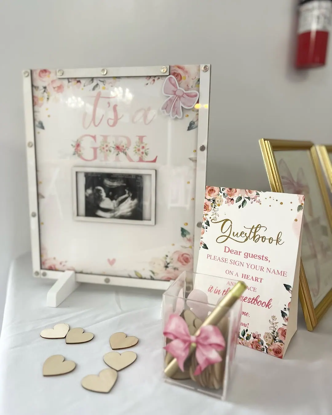 Elegant coquette baby shower guestbook sign with floral accents.