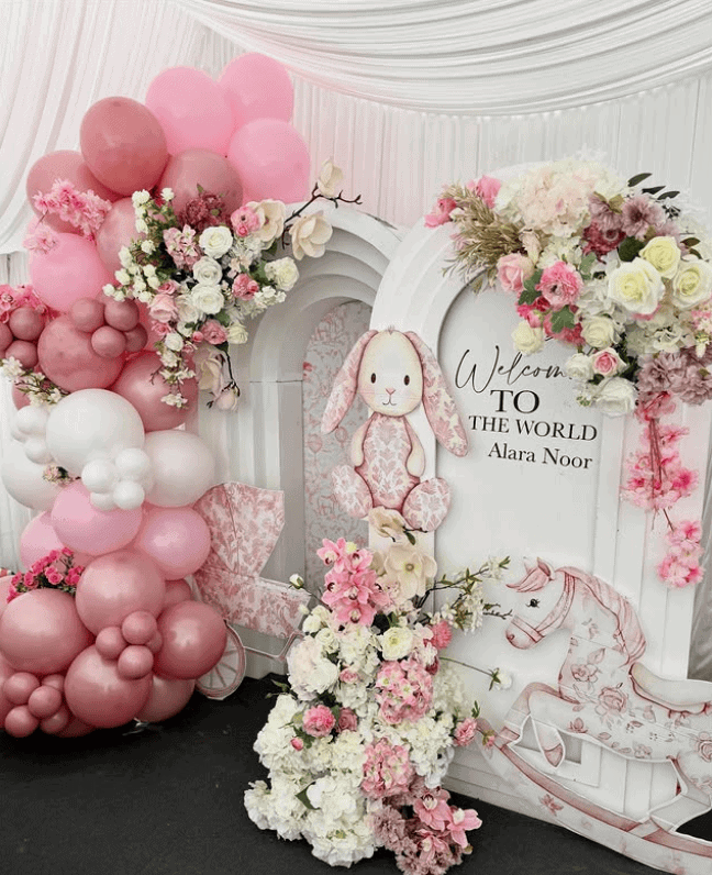 Colorful floral arrangements and balloons for a baby shower celebration.