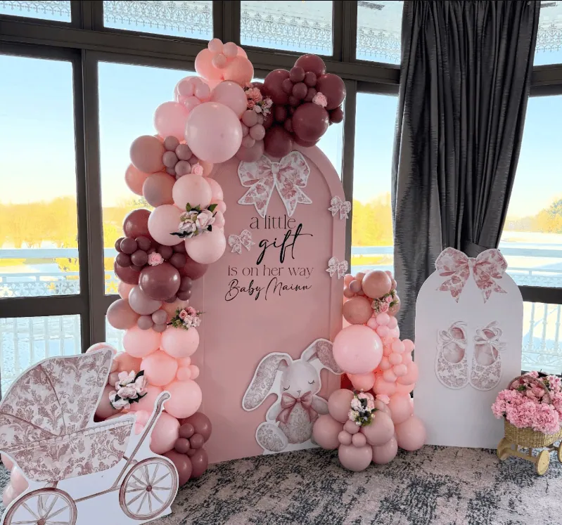 Elegant pink and maroon balloon arch for baby shower celebration.