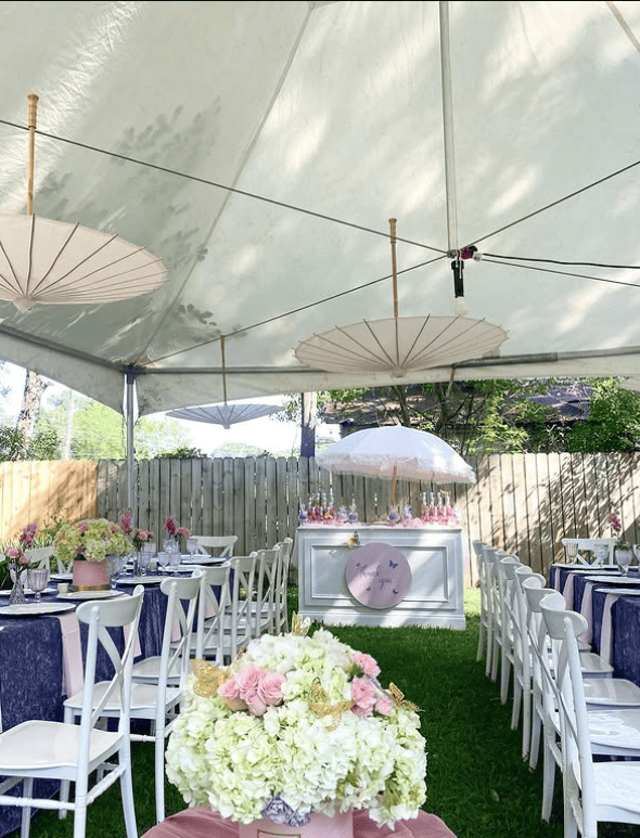 Outdoor baby shower with floral arrangements and parasols.