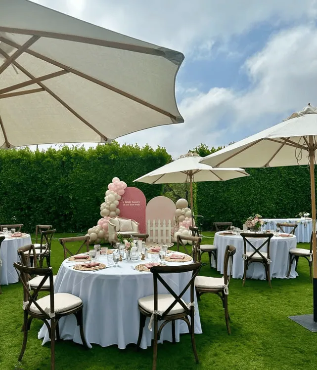 Beautiful outdoor garden baby shower with decorated tables, balloons, and umbrellas.