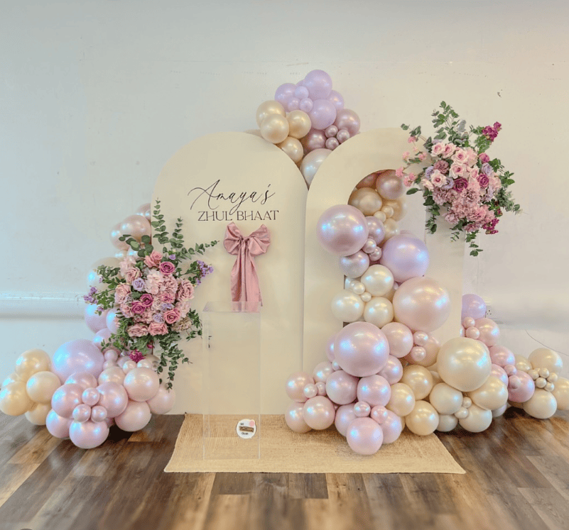 Elegant baby shower backdrop with pastel balloons and floral decor for a spring celebration.