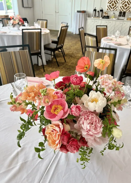 Beautiful floral arrangement with pink, peach, and white blooms for a baby shower celebration.