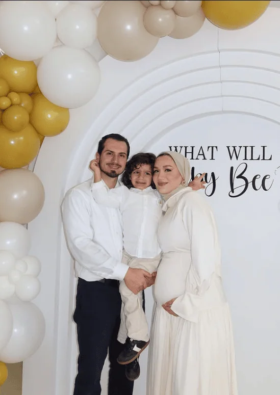 Happy family with pregnant mother, father, and child at gender reveal celebration.