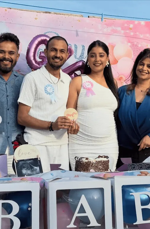 Happy family celebrating gender reveal party outdoors.