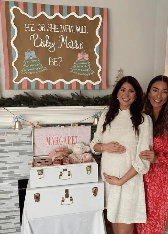 Pregnant woman with friend at gender reveal party with gift box and decorations.