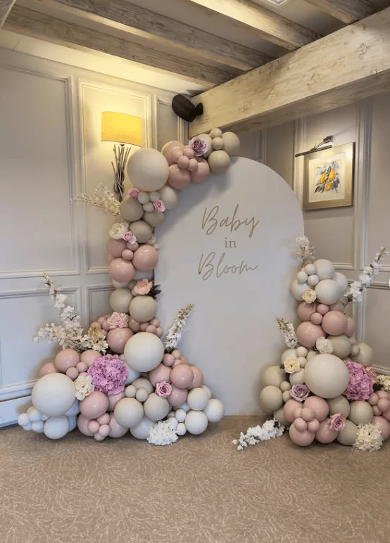 Elegant balloon arch with pastel pink, white, and lavender balloons for baby shower celebration.