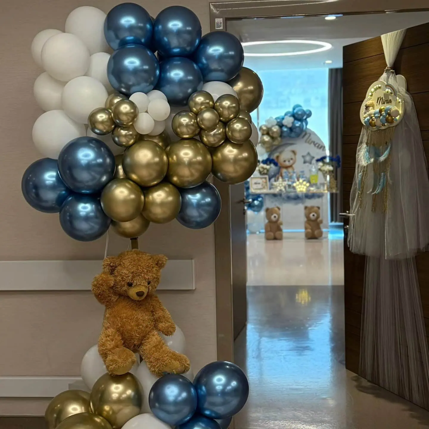 Balloon arrangement with teddy bear for baby shower celebration.
