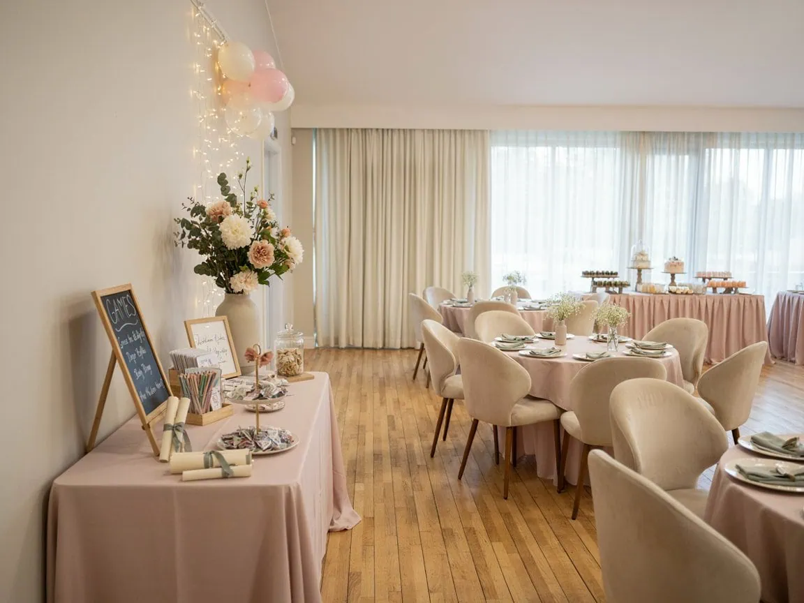 Chic baby shower room with pastel-colored tables, floral arrangements, and balloons.